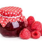 Raspberry jam and fresh berries isolated on white